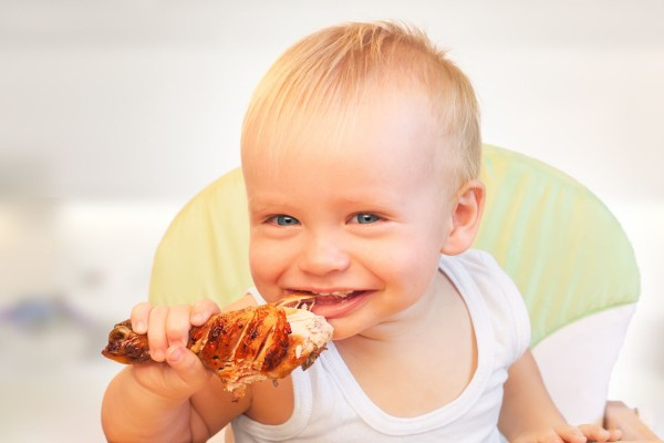 Ребенок ест курицу